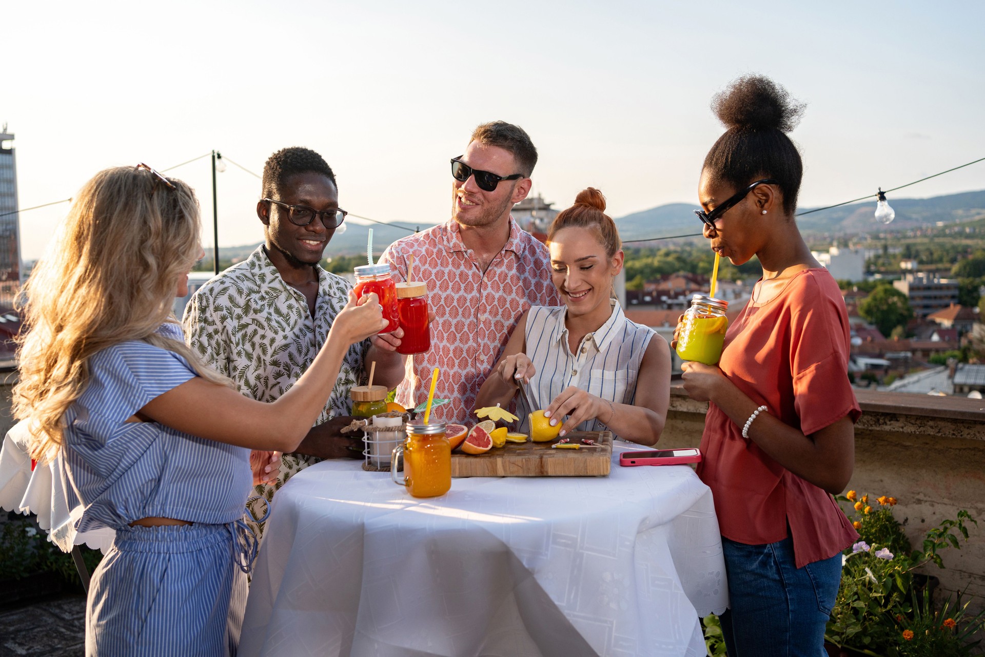 Young group of friends toasting with fruit mocktails at a party