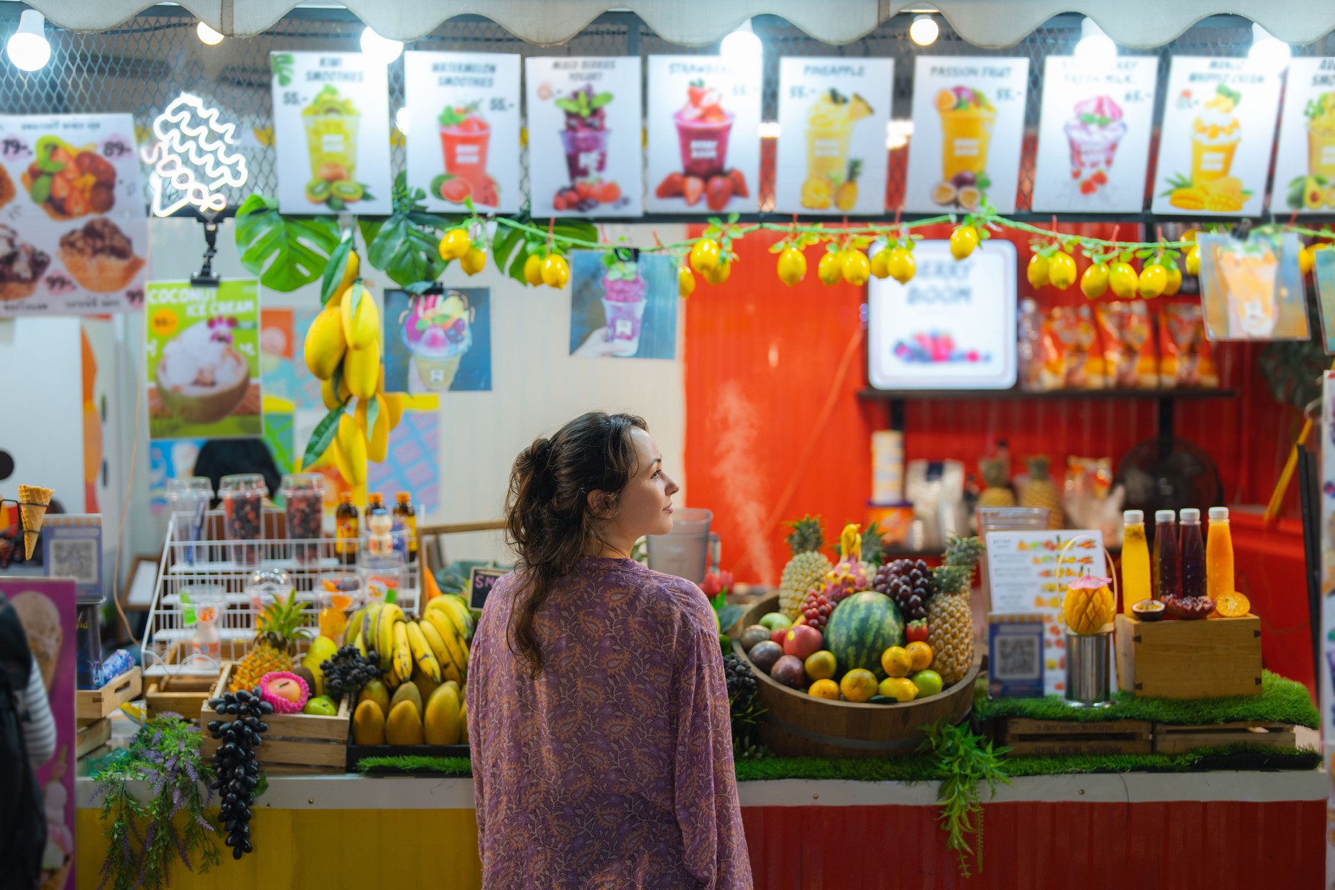 Woman ordering smoothie on  night market in Bangkok